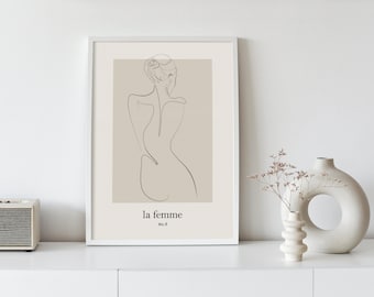 May include: A framed print with a line drawing of a woman in a neutral beige color. The text "la femme" and "no. 6" are printed below the drawing.