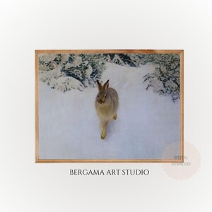 Puede incluir: Impresión enmarcada de una liebre marrón corriendo por un paisaje nevado. La obra de arte está enmarcada en un marco de madera marrón claro. El texto "BERGAMA ART STUDIO" es visible en la parte inferior. Estilo vintage.