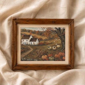 May include: A framed landscape painting featuring a white cottage with a red chimney, a winding dirt path, and a group of sheep grazing in a field. The scene includes autumn trees with orange foliage and several pumpkins in the foreground.