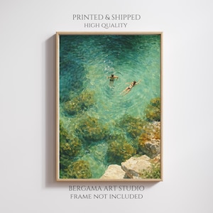 May include: A framed art print depicting two people swimming in clear turquoise water. The water reveals underwater rocks and a rocky shoreline. The print is labeled "PRINTED & SHIPPED HIGH QUALITY" and "BERGAMA ART STUDIO FRAME NOT INCLUDED".