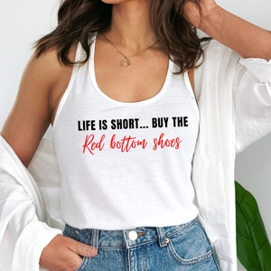 Pu&ograve; includere: Canotta bianca con la scritta "Life is short... Buy the Red bottom shoes" in lettere nere e rosse.