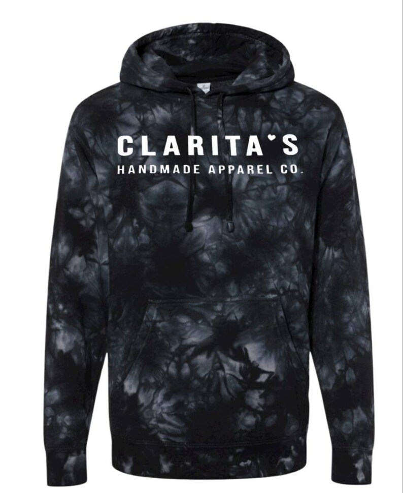 Puede incluir: Sudadera con capucha de color negro tie-dye con texto blanco que dice "Clarita's Handmade Apparel Co."
