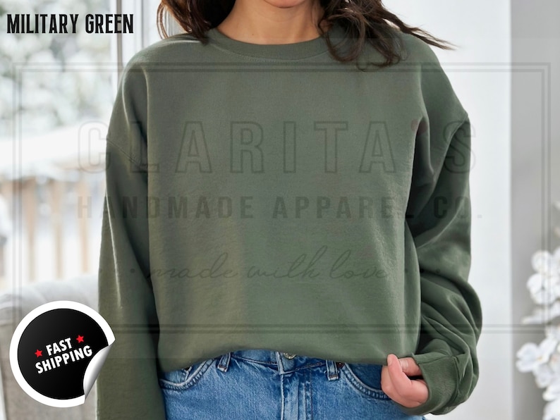 Model is wearing a blank military green crew neck sweatshirt.  The sweatshirt is made of a soft, comfortable fabric and has a relaxed fit. The sweatshirt is perfect for everyday wear or for special occasions.