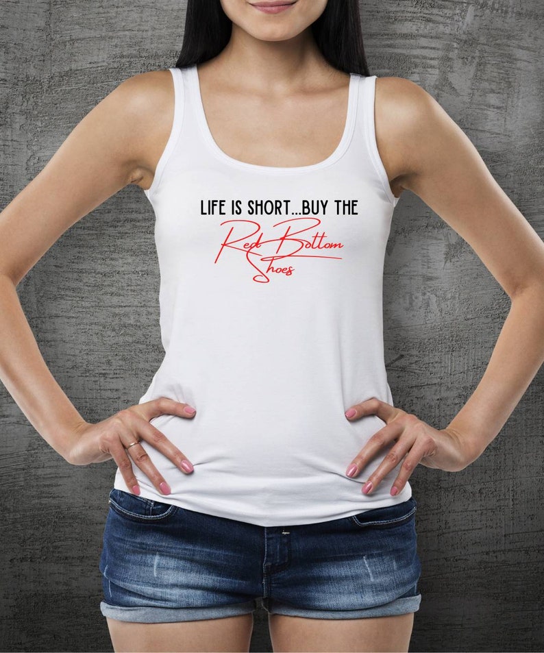 K&ouml;nnte beinhalten: Ein wei&szlig;es Tanktop mit dem Text "LIFE IS SHORT...BUY THE Red Bottom Shoes" in roten Buchstaben.