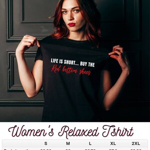 Pu&ograve; includere: Maglietta nera a taglio rilassato con la scritta "LIFE IS SHORT... BUY THE Red bottom shoes" stampata in rosso sul davanti. Tabella delle taglie con misure in pollici per S, M, L, XL e 2XL.