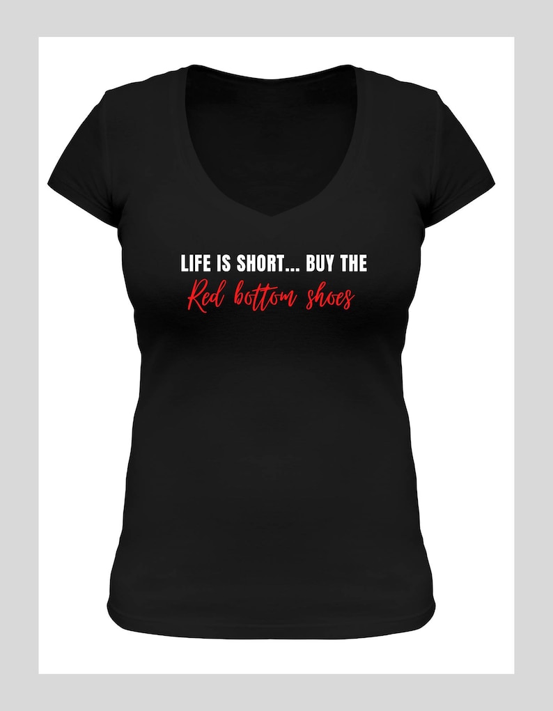 Pu&ograve; includere: Maglietta nera a collo a V con il testo "LIFE IS SHORT... BUY THE Red bottom shoes" in lettere bianche e rosse.