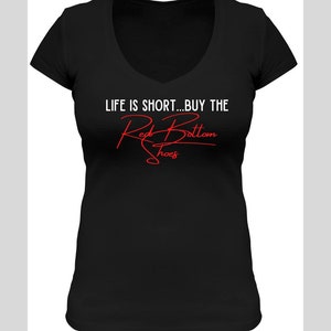 K&ouml;nnte beinhalten: Schwarzes T-Shirt mit V-Ausschnitt und dem Text "LIFE IS SHORT...BUY THE Red Bottom Shoes" in wei&szlig;er und roter Schrift.