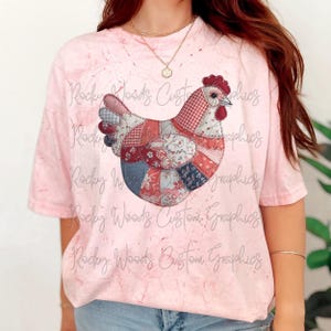 Könnte beinhalten: Hellrosa T-Shirt mit einem Patchwork-Hühner-Design. Das Huhn besteht aus verschiedenen Stoffmustern in Rot, Blau und Weiß. Der Text "Rocky Woods Custom Graphics" ist auf dem Shirt aufgedruckt.