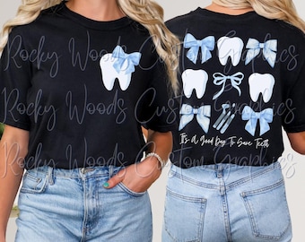 Op de afbeelding: Twee zwarte T-shirts met een blauw en wit tandontwerp en blauwe strikken. De achterkant van een shirt zegt "Het is een goede dag om tanden te redden".
