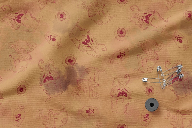 May include: A brown fabric with a repeating pattern of a spooky, red-toned monster with a skull and crossbones, and a red eye. There are also safety pins and a black spool on the fabric.