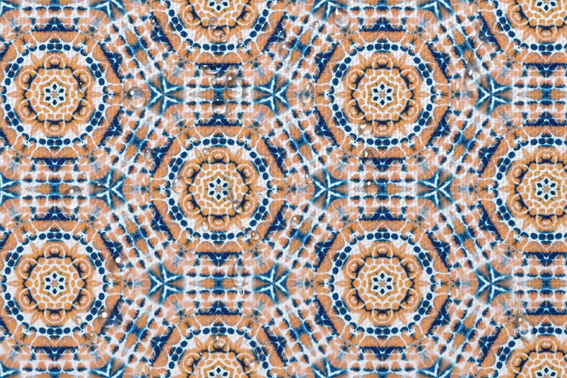 May include: A repeating pattern of blue, orange, and white geometric shapes with water droplets on the surface.