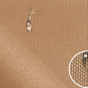 Könnte beinhalten: Nahaufnahme eines braunen Stoffes mit einer strukturierten Webart. Wassertropfen sitzen auf der Oberfläche und zeigen die wasserabweisenden Eigenschaften des Stoffes.
