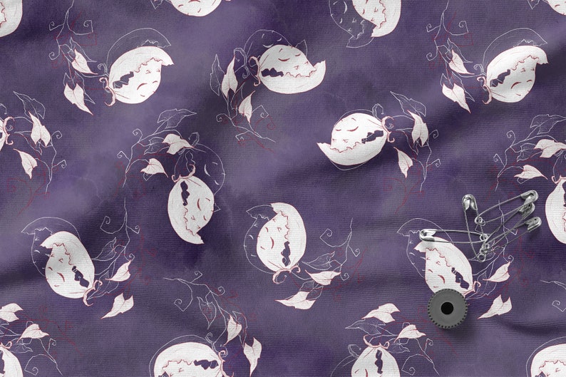 May include: Purple fabric with a white floral pattern. The fabric has a subtle watercolor effect. There are safety pins and a black spool of thread on the fabric.