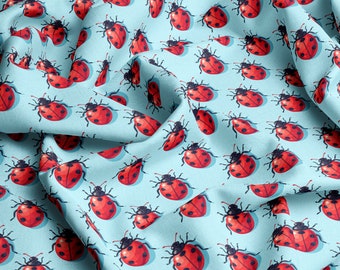 May include: A blue fabric with a repeating pattern of red ladybugs. The ladybugs have black spots and are arranged in a staggered pattern.