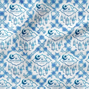 Könnte beinhalten: Ein nahtloses Muster mit einem blauen und weißen Aquarelldesign mit dem Text "Ramadan Kareem", der sich wiederholt. Das Muster enthält auch Halbmonde, Sterne und Laternen.