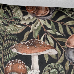 May include: A black background with a repeating pattern of green leaves, brown mushrooms, and brown snails. The mushrooms have white stems and brown caps with white spots. The snails have brown shells and grey bodies. The pattern is repeated throughout the image. 25cm/9.85 inch