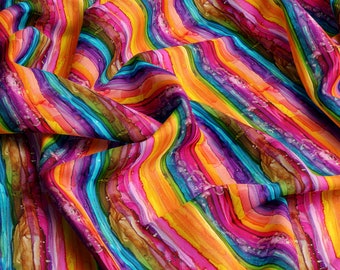 May include: A colorful fabric with a striped pattern in shades of yellow, orange, red, pink, purple, blue, green, and brown. The fabric is folded and draped, creating a wavy effect.