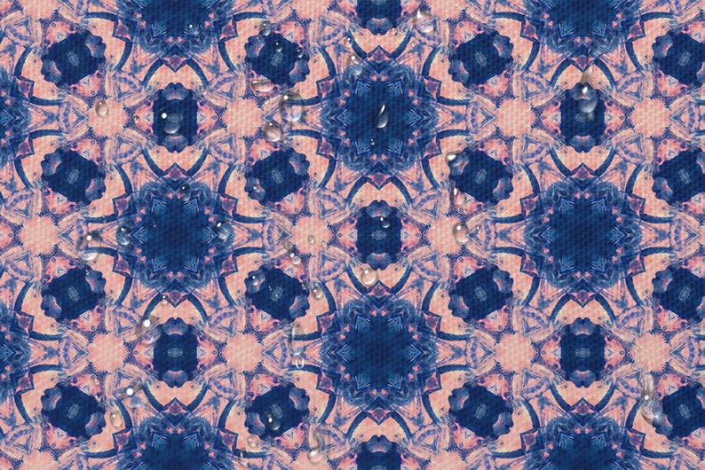 May include: A pink and blue patterned fabric with a repeating geometric design. Water droplets are scattered across the surface.