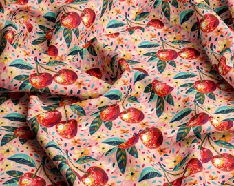 May include: A pink fabric with a repeating pattern of red cherries, green leaves, and yellow flowers. The fabric is folded and has a textured surface.