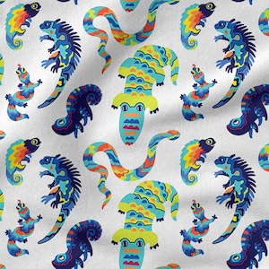 May include: A white fabric with a repeating pattern of colorful lizards, snakes, and alligators. The lizards are green, blue, and yellow with black accents. The snakes are orange, yellow, and blue with black accents. The alligators are green, yellow, and blue with black accents.