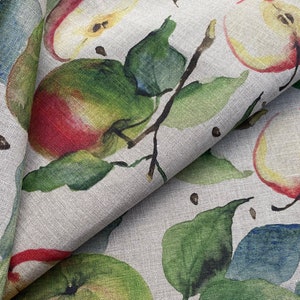 May include: A beige linen fabric with a repeating pattern of red and green apples, leaves, and black dots.
