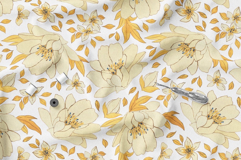 K&ouml;nnte beinhalten: Wei&szlig;er Stoff mit einem sich wiederholenden Blumenmuster in Creme und Gelb. Das Design umfasst gro&szlig;e, pfingstrosenartige Bl&uuml;ten, kleinere Bl&uuml;ten und goldene Bl&auml;tter. N&auml;hutensilien, darunter Garnrollen und ein Nahttrenner, sind auf dem Stoff verstreut.