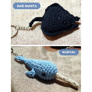 K&ouml;nnte beinhalten: Zwei geh&auml;kelte Tier-Schl&uuml;sselanh&auml;nger. Der erste ist ein schwarzer Mantarochen mit einer silbernen Kette. Der zweite ist ein blauer Narwal mit einem wei&szlig;en Horn und einer silbernen Kette. Die Schl&uuml;sselanh&auml;nger befinden sich auf einem braunen Jute-Hintergrund.