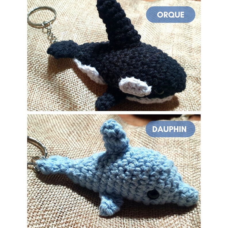 K&ouml;nnte beinhalten: Zwei geh&auml;kelte Stofftier-Schl&uuml;sselanh&auml;nger. Der erste ist ein schwarz-wei&szlig;er Orca-Schl&uuml;sselanh&auml;nger mit wei&szlig;em Bauch und einem wei&szlig;en Fleck um das Auge. Der zweite ist ein hellblauer Delfin-Schl&uuml;sselanh&auml;nger mit schwarzem Auge.