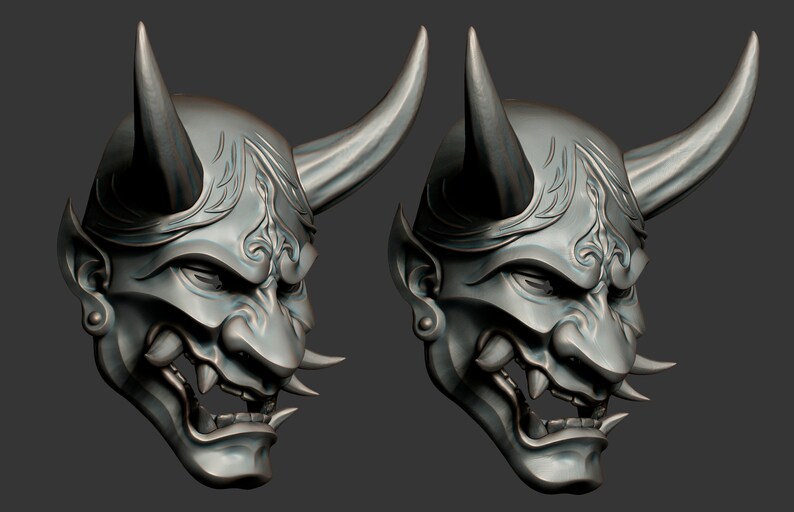 May include: Two silver-colored Japanese Oni masks with horns and intricate details. The masks have a fierce expression with sharp teeth and a detailed design.
