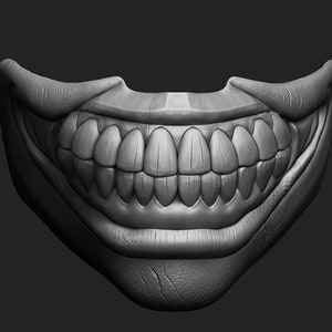 Op de afbeelding: Een close-up van een grijs, gebeeldhouwd, grijnzend mondmasker met een brede, tandenrijke glimlach. Het masker is gemaakt van een glad, getextureerd materiaal en heeft een realistische uitstraling.