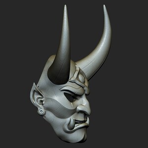 May include: A grey, detailed, wooden mask with horns and a fierce expression. The mask has a textured surface and appears to be hand-carved.