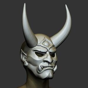 May include: A white, detailed, sculpted mask with horns, a third eye, and a fierce expression. The mask is worn on a bald head with a single earring.