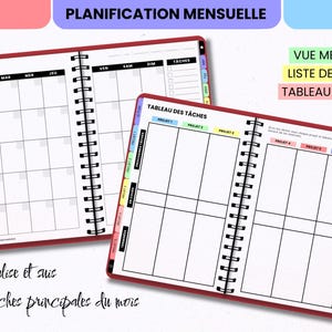 May include: A spiral-bound planner with red covers featuring a monthly calendar view labeled JANVIER and a Kanban task board labeled TABLEAU DES T&Acirc;CHES. The pages include colorful side tabs for months and projects, with black grid lines and text.