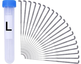 Puede incluir: Un juego de 25 agujas de fieltro de color plateado con punta doblada, dispuestas en forma de abanico. Las agujas están empaquetadas en un tubo de plástico transparente con tapa azul y una etiqueta que dice "10ml" y "L".