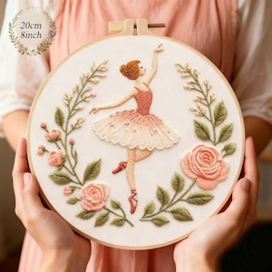 Può includere: Ricamo su telaio raffigurante una ballerina in tutù rosa, circondata da rose e verde ricamati. L'opera, tenuta in un telaio di legno, misura 20 cm di diametro.