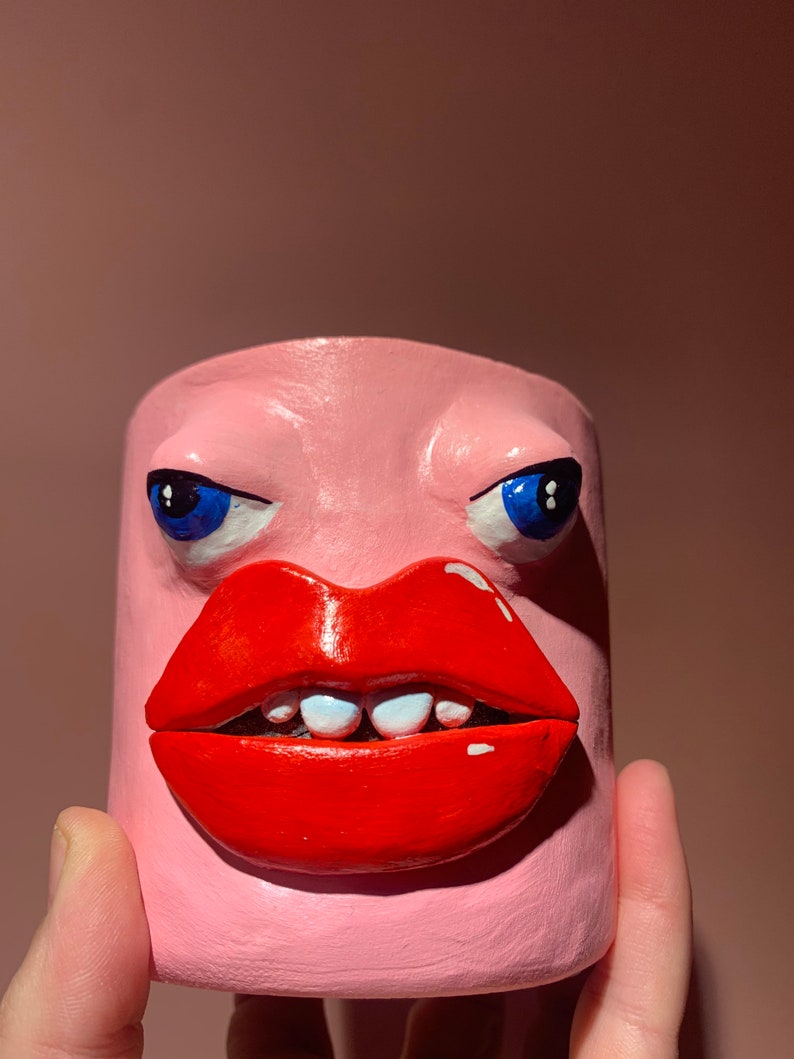 Peculiar cabeza extraña cara olla ojos y labios rosados arte extraño imagen 5