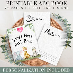 May include: Printable Baby's First ABC Book with 29 pages and 5 free table signs. The cover features a pink heart, a gray elephant, a giraffe, and a zebra. The book is personalized with the text "Baby's First ABC Book".