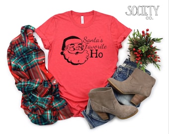 May include: Red t-shirt with a black and white illustration of Santa Claus and the text "Santa's Favorite Ho".