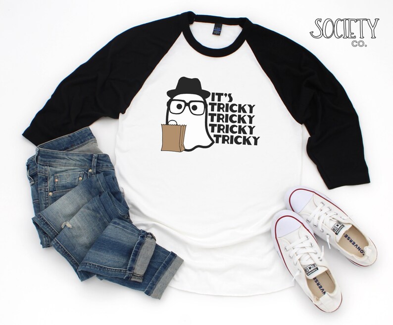 May include: White and black baseball style t-shirt with a ghost wearing a hat and glasses and holding a brown paper bag. The text on the shirt reads "It's Tricky Tricky Tricky Tricky".
