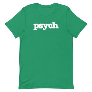 Puede incluir: Una camiseta verde de manga corta con la palabra "psych" impresa en blanco en la parte delantera.