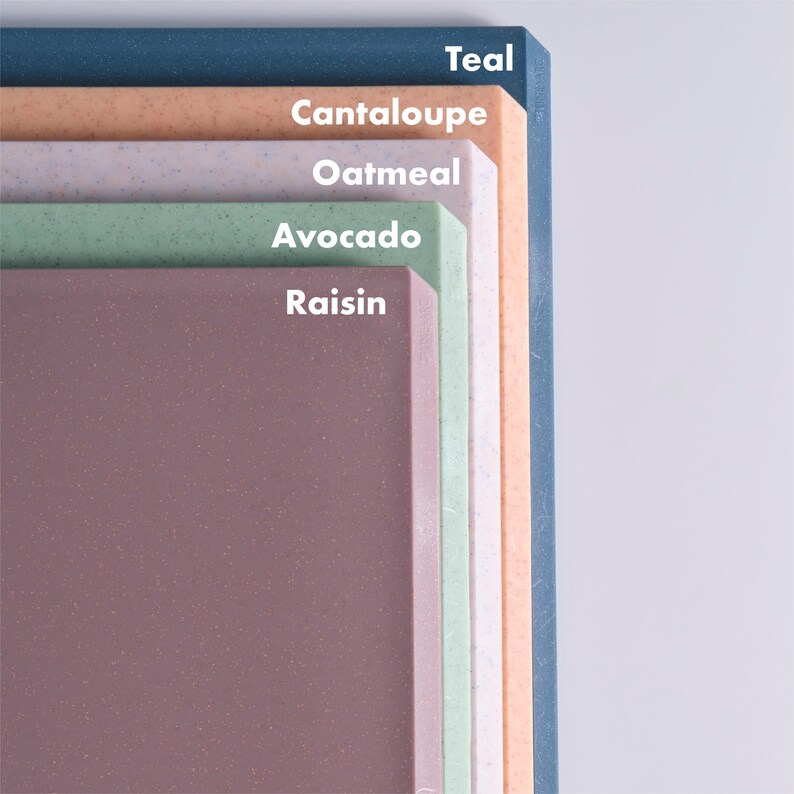 May include: A stack of colorful rectangular boards in shades of teal, cantaloupe, oatmeal, avocado, and raisin. Each board has a speckled texture. The names of the colors are printed in white text on the boards.
