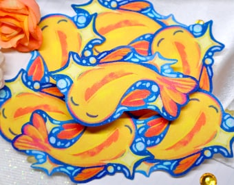 May include: A collection of die-cut stickers featuring a stylized yellow fish with orange fins and closed eyes, surrounded by blue water-like accents and star shapes. The fish design is repeated in various orientations across the group.