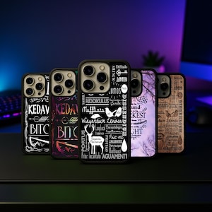 May include: A collection of five black phone cases with various designs and text. The cases feature white text and graphics, including phrases like "Riddikulus" and "Expecto Patronum." The cases are displayed on a dark surface.