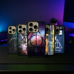May include: A collection of phone cases with various designs. The cases feature images of the Deathly Hallows symbol, galaxy patterns, and the word "Always" in a stylized font. The cases are black with a black camera ring.