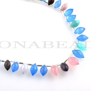 May include: A strand of gemstone beads in various colors, including blue, pink, and brown. The beads are faceted and have a teardrop shape. The beads are strung on a silver wire.