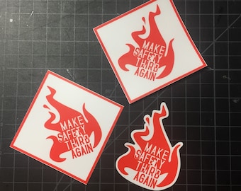 May include: Three white square stickers with red flames and the text "Make Safety Third Again".