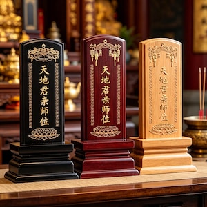 Könnte beinhalten: Drei Holztafeln mit chinesischen Schriftzeichen, jeweils auf einem rechteckigen Sockel montiert. Die Tafeln sind schwarz, weinrot und helles Holz, mit goldfarbenen dekorativen Elementen und Text. Der Text lautet "Himmel, Erde, Herrscher, Verwandte, Lehrer, Position".