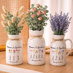 May include: Three white ceramic vases with floral arrangements. Each vase has a decorative twine bow and the text "Nana's Garden" with names and "love grows here". The vases hold dried flowers, pink roses, and lavender.