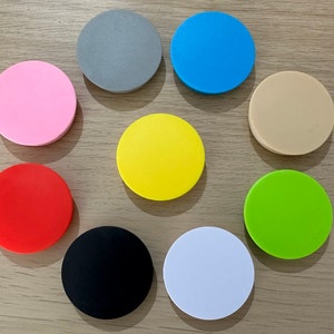 May include: Assortment of ten round, flat, colourful discs. The discs are in the following colours: pink, red, grey, blue, beige, yellow, green, black, and white.