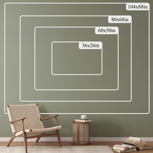 May include: A green wall with four white rectangular frames outlining different sizes of wall art. The frames are labeled with the dimensions in inches: 36x26in, 60x50in, 80x68in, and 104x88in. A wooden chair and a small wooden table with a book on top are in the foreground.